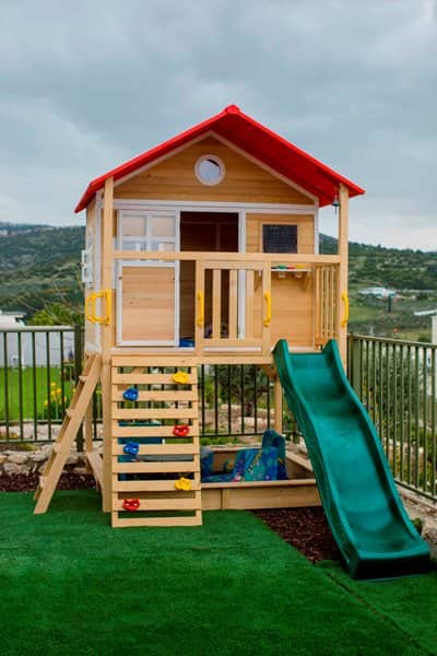 בית עץ לחצר עשוי מעץ אורן איכותי בצבעי עץ ואדום עם מרפסת ומגלשה בכחול או ירוק